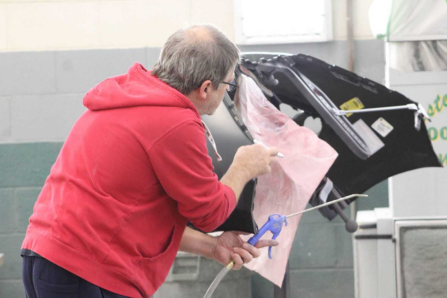 Repair technician applies protective sheet before painting